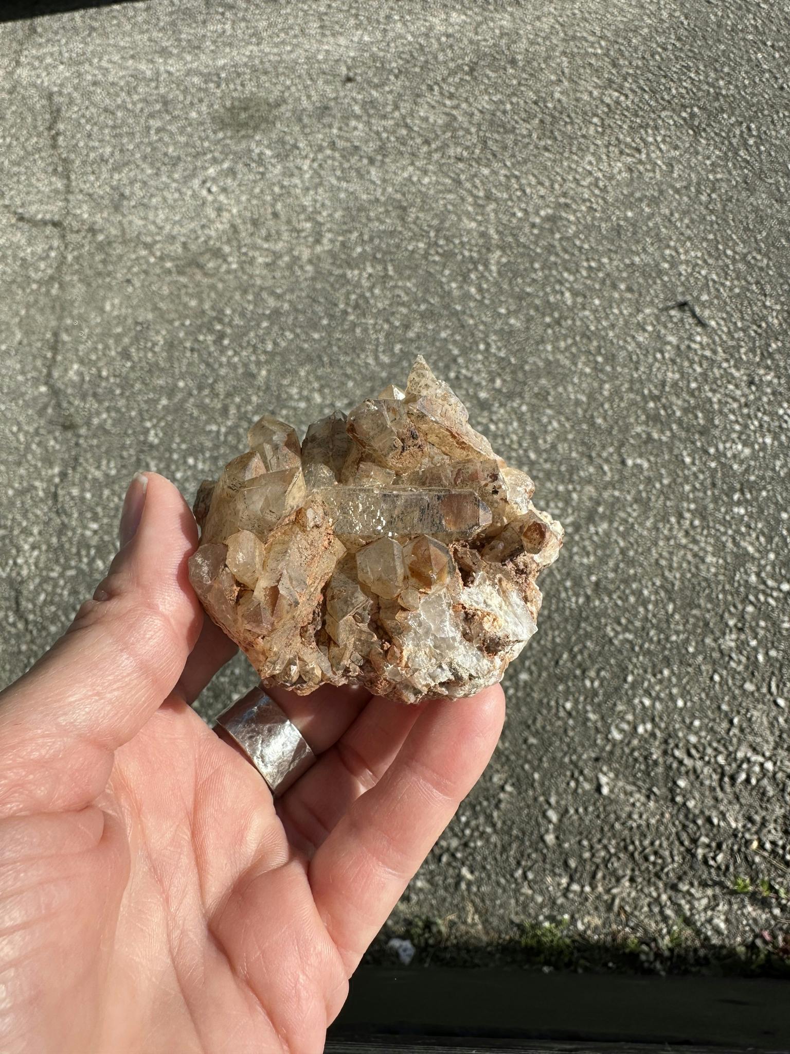 Litet bergkristall kluster med orangaktiga inneslutningar