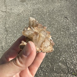 Litet bergkristall kluster med orangaktiga inneslutningar