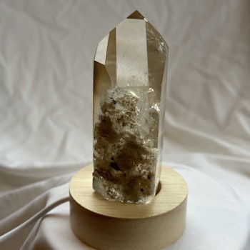 Ljus bergkristall spets med rutiler och en delvis rå sida