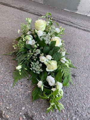 Liggande dekoration med enbart vita blommor och mycket grönt (bilden ca 1200:-)