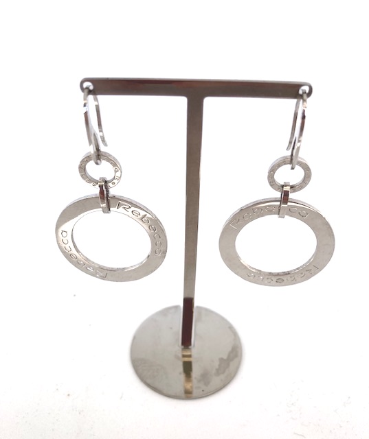 Rebecca hängande örhänge i stål form av 1 stor och en liten cirkel med texten Rebecca hos EriCsson Ur och Guld
