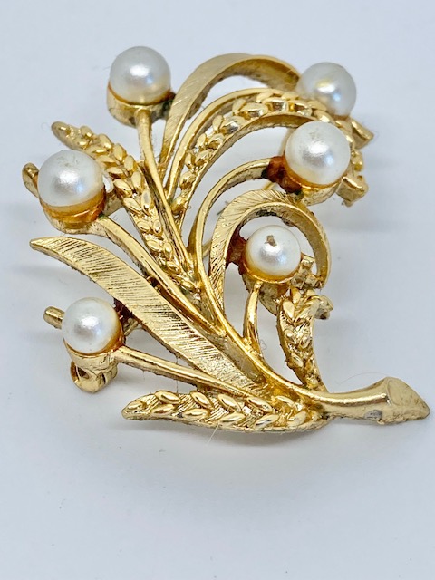 Vintage vacker bijouteribrosch förgylld med vita pärlor märke Lisner hos EriCsson Ur och Guld