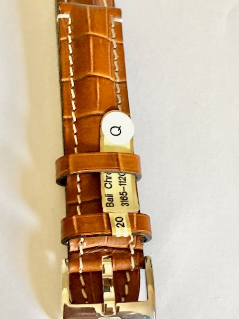 Sportigt klockarmband. Brunt läder med vita stickningar och stålspänne. Bredd 20 mm
