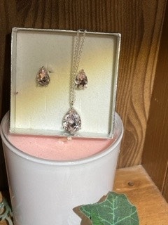 halsband och örhänge i silverfärg med rosa kristall