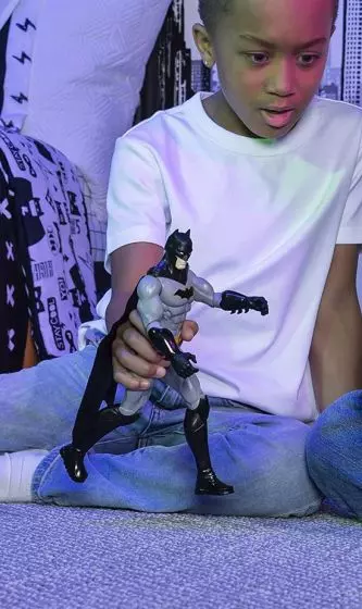 pojke som leker med batman actionfigur