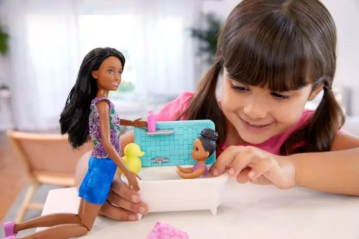 flicka som leker med barbie