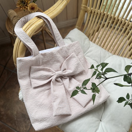 Handsydd tygpåse med rosett - smårutig beige