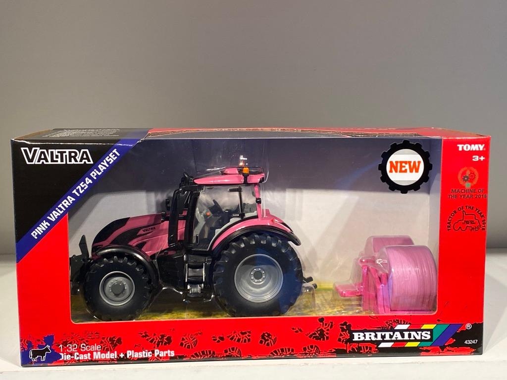 Skala 1/32 Britains Traktor Valtra TZ54 med baklyft och två rundbalar, allt i rosa.