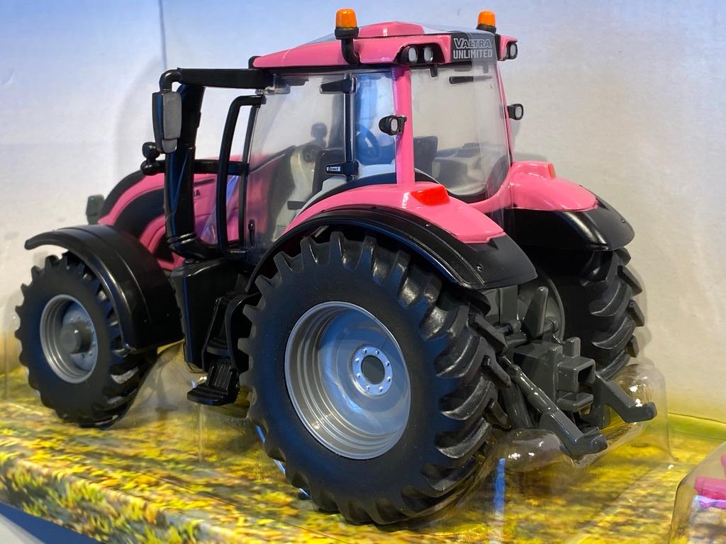 Skala 1/32 Britains Traktor Valtra TZ54 med baklyft och två rundbalar, allt i rosa.