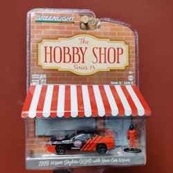 Skala 1/64 Nissan Skyline R34 1999 med förare "Hobby Shop" fr Greenlight