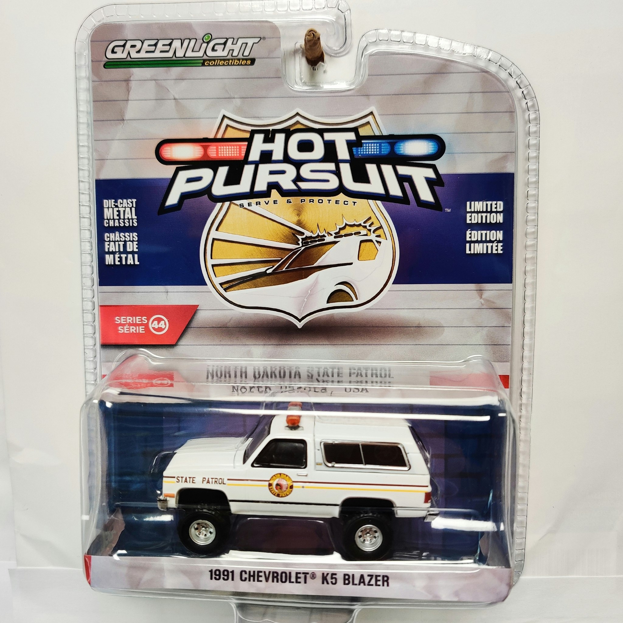 Skala 1/64 Greenlight, "Hot Pursuit", Chevrolet K-5 Blazer 91' North Dakota  State Patrol - YAKOL