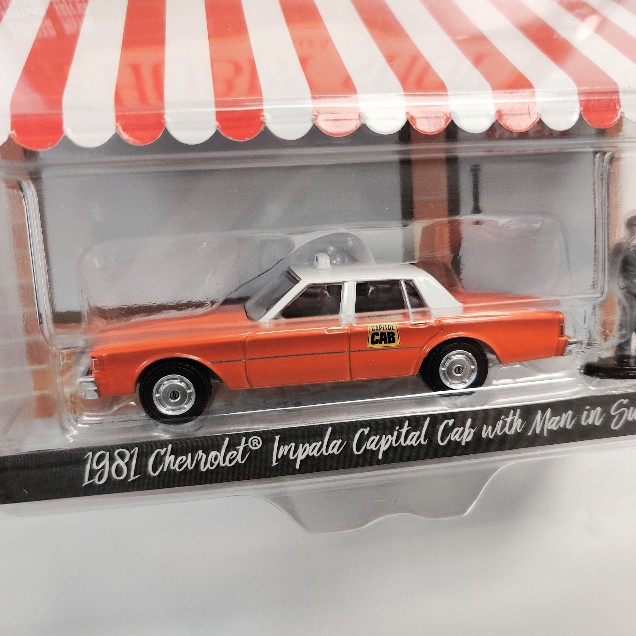 Skala 1/64 Greenlight "The Hobby Shop" 1981 Chevrolet Capital Cab w man in suit