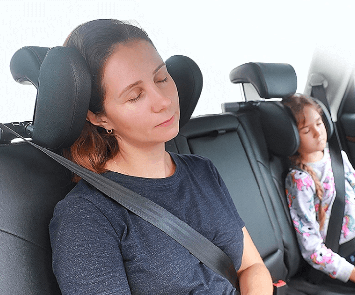 Vuxen som vilar mot ett nackstöd i bilen
