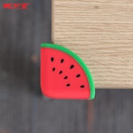 Hörnskydd som ser ut som en röd vatten melon, monterat på ett bordshörn