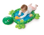 Baby som leker med lekmatta till baby som ser ut som en sköldpadda