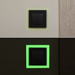 bild som visar hur självlysande tejp ser ut kring en lysknapp under dag och natt