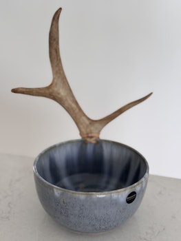 Skål med renhorn i blåspräcklig glasyr.