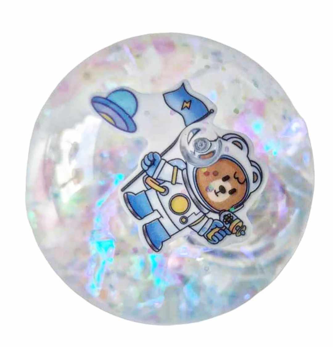 En vätskefylld boll med skimrande konfetti i samt en astronaut med flagga, kasta bollen i golvet och lampan inuti bollen börjar blinka i rött och blått.