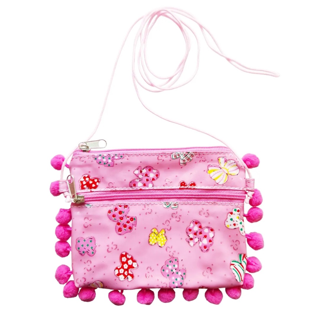 Söt rosa axelremsväska för barn, väska har små bollar runt sidorna och ett rosettmönster på