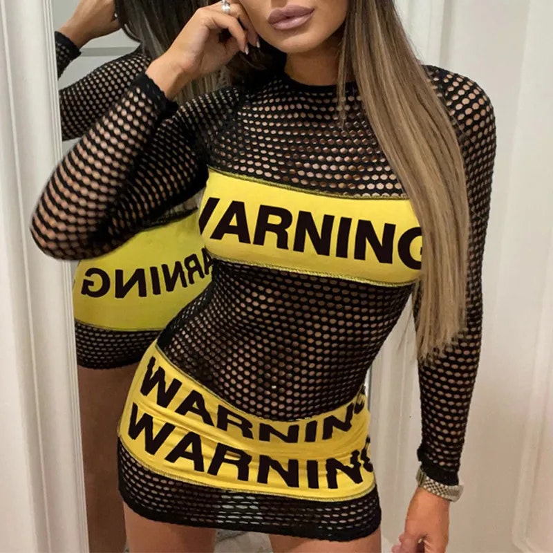 Sexig modell med varning på klänningen som hon har på sig.