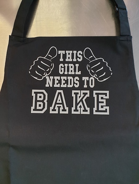 Förkläde med tryck "This Girl Needs To Bake" FYNDHÖRNA