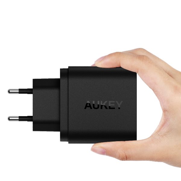 Aukey mobilladdare med 2 uttag med Quick Charge 3.0 i handen
