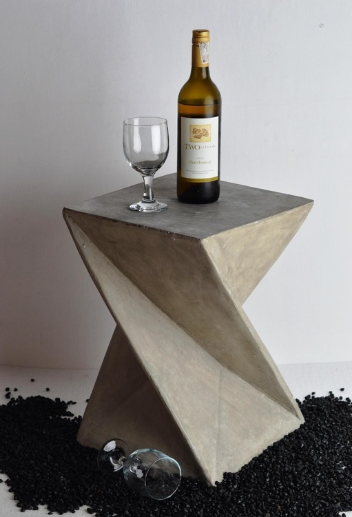 Sidobord av betong med vinflaska och vinglas på