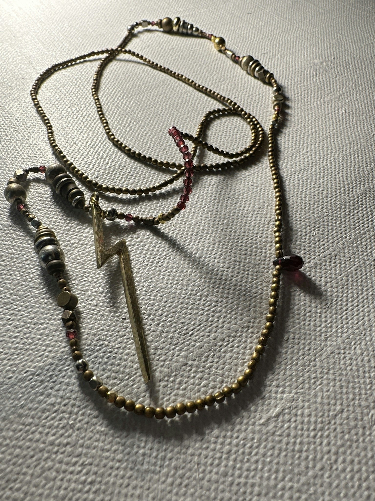 ”Halsband” med  svagt lila glas pärlor och med  brons färgade pärlor med en brons blixt