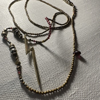 ”Halsband” med  svagt lila glas pärlor och med  brons färgade pärlor med en brons blixt