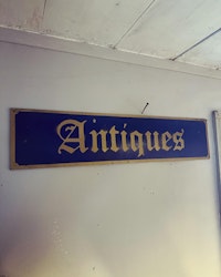 Skylt ”antiques”
