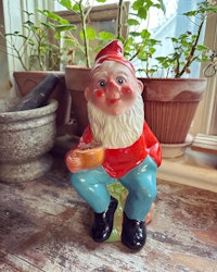 Tomte - sittande som kan hålla i ett ljus