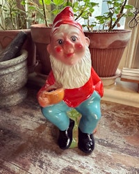 Tomte - sittande som kan hålla i ett ljus