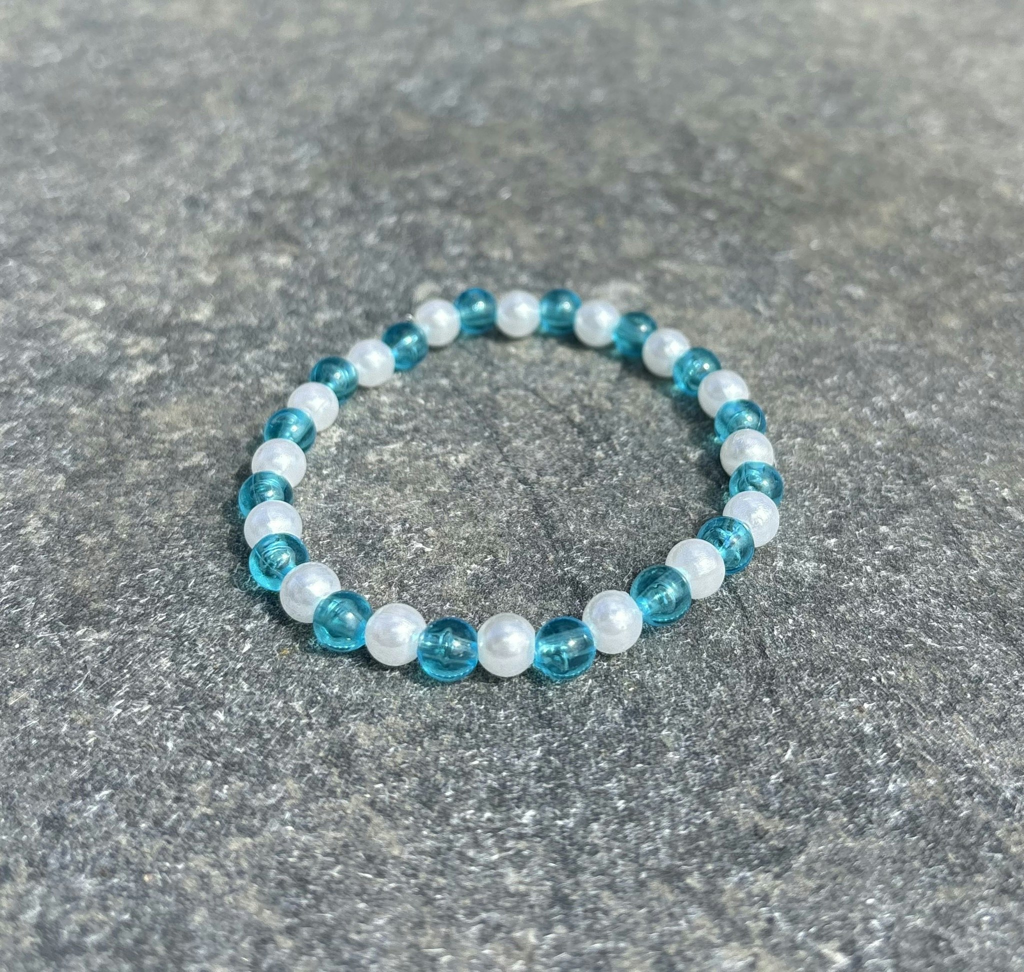 Turkosblå och vit armband med akrylpärlor