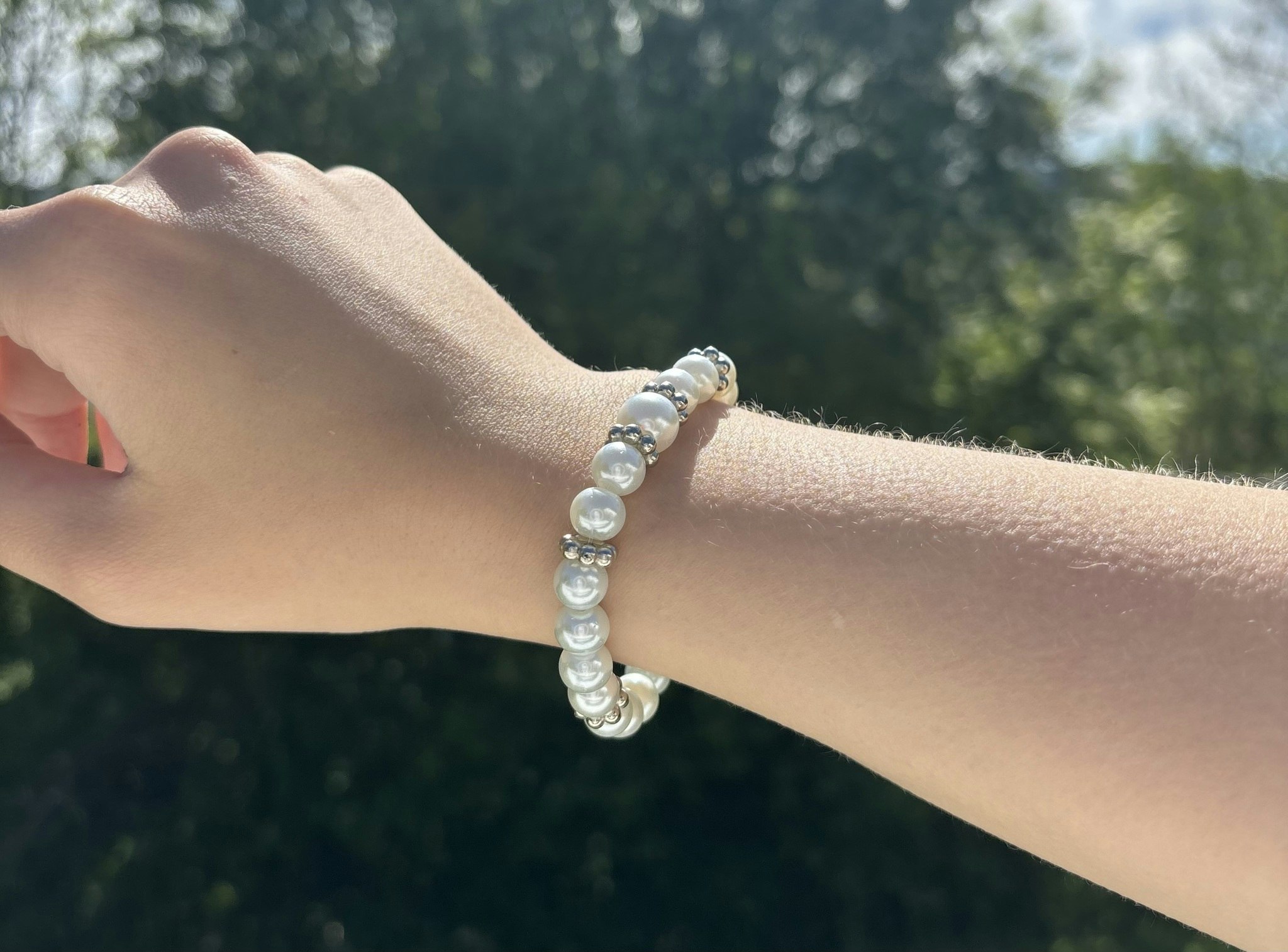 Armband med vita glaskulor och silvriga detaljer