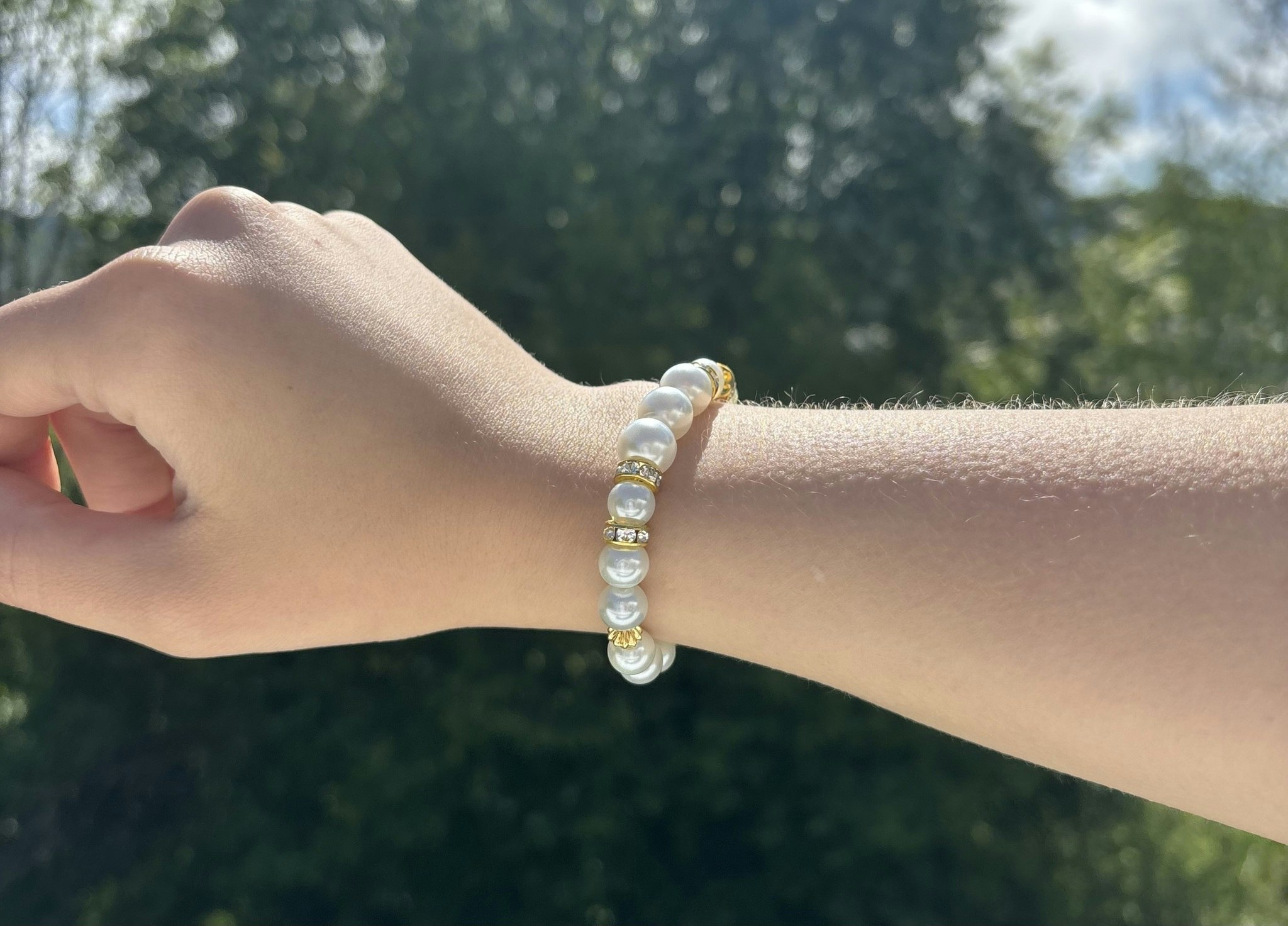 Armband med vita glaskulor och guldiga detaljer