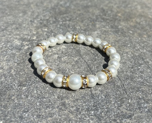 Armband med vita glaskulor och guldiga detaljer 1