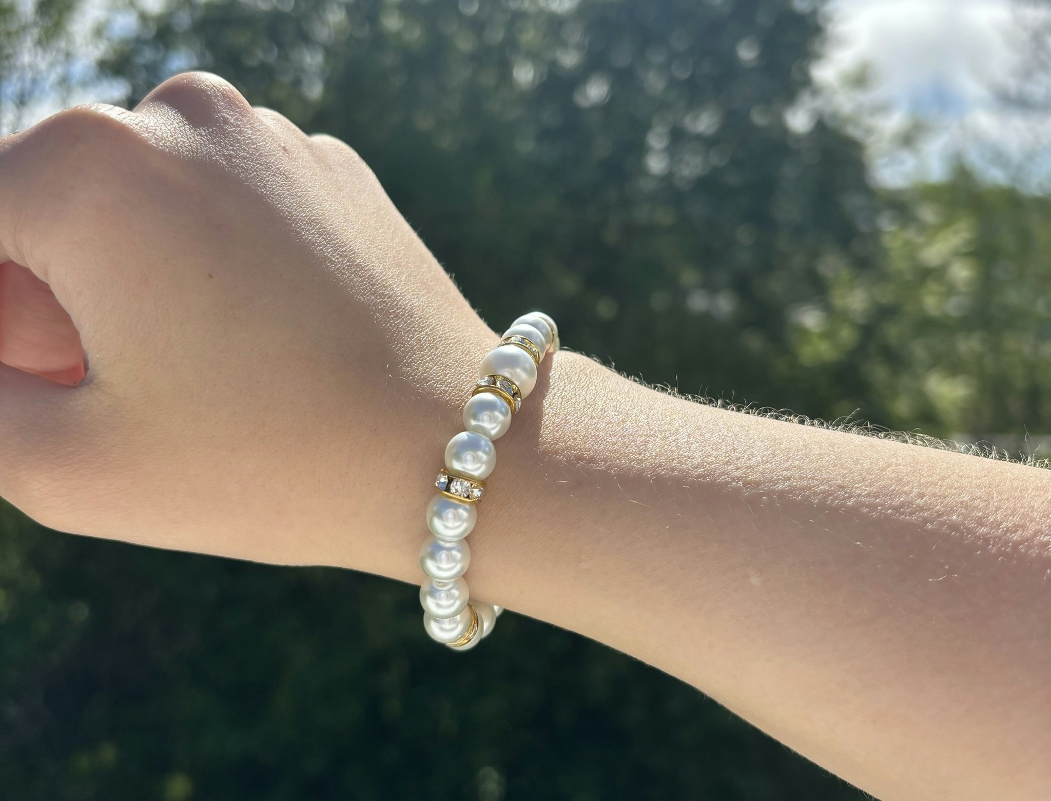 Armband med vita glaskulor och guldiga detaljer 1