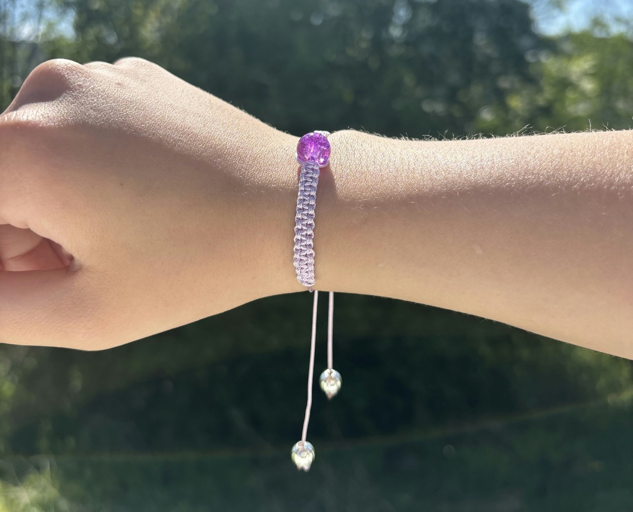 Lila makrame armband med en krackelerad glaspärla