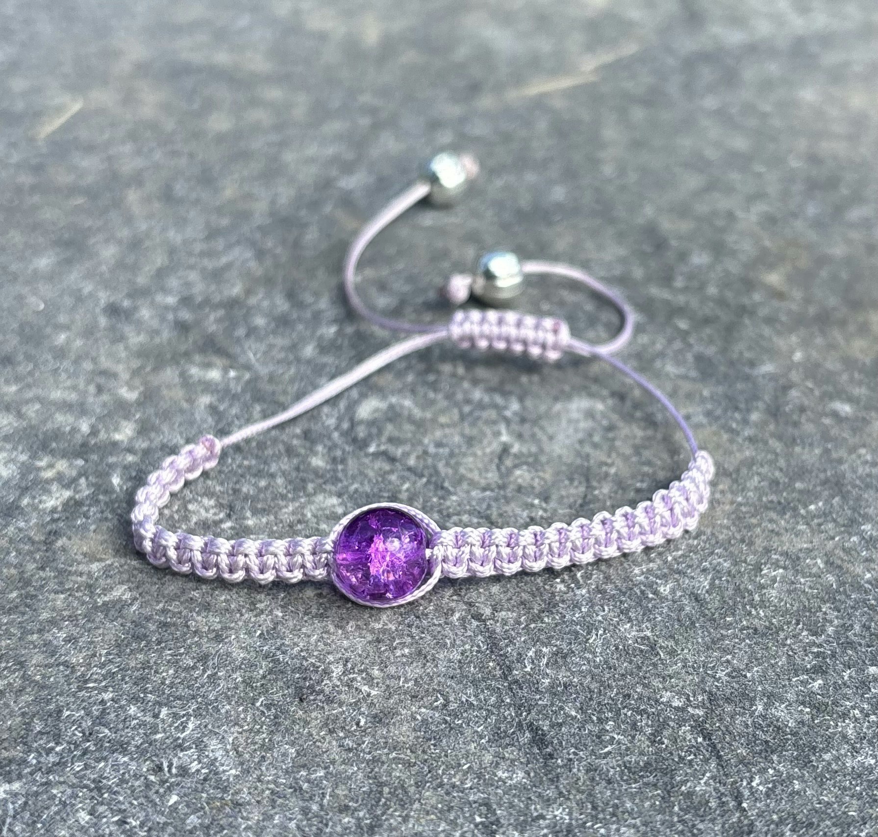 Lila makrame armband med en krackelerad glaspärla