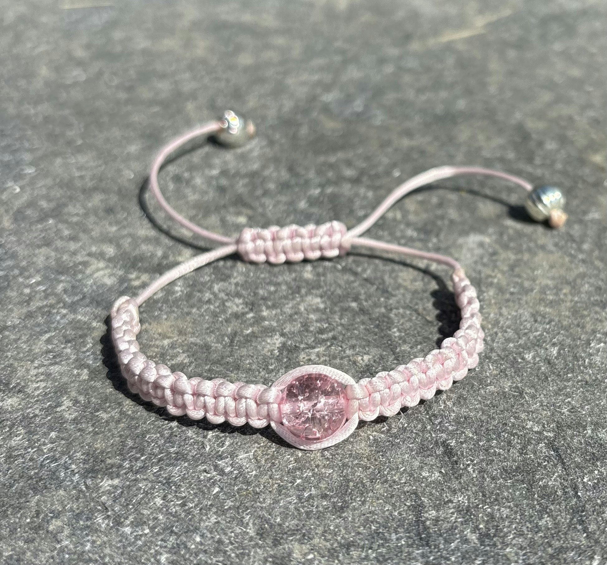 Ljusrosa makrame armband med en krackelerad glaspärla