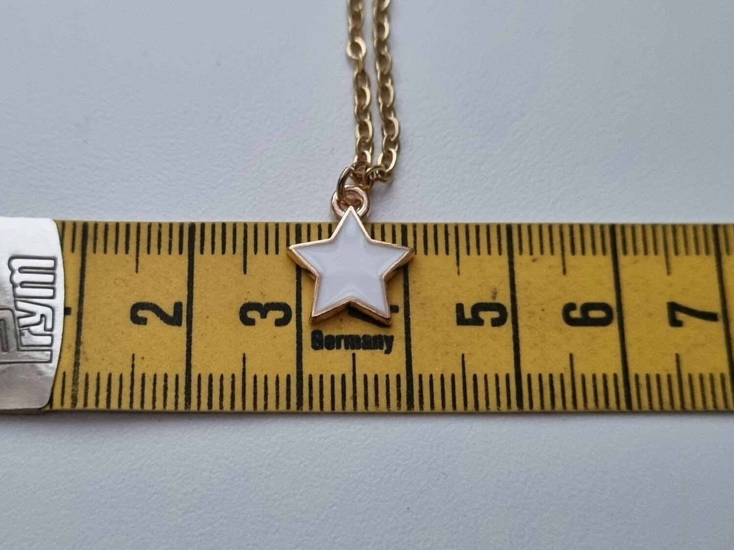 Guldfärgat halsband med en vit stjärna