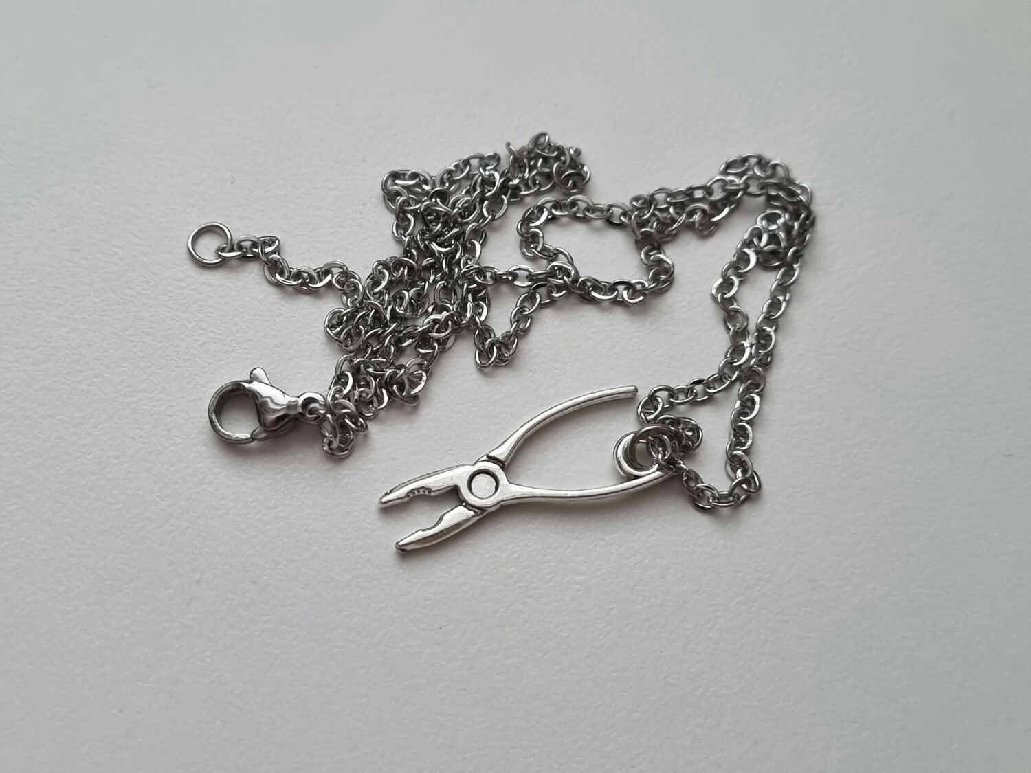 Silverfärgat halsband med en tång