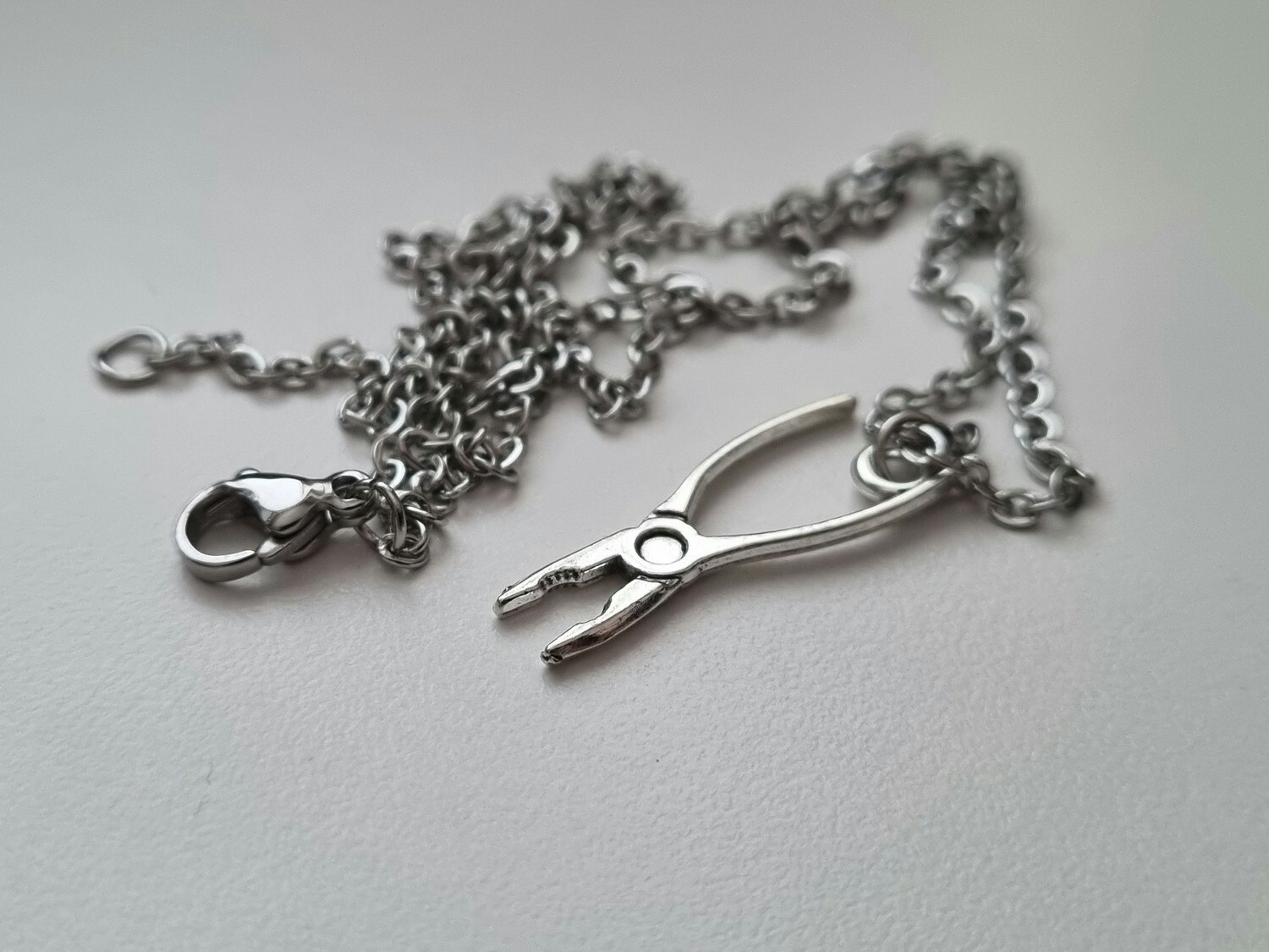 Silverfärgat halsband med en tång