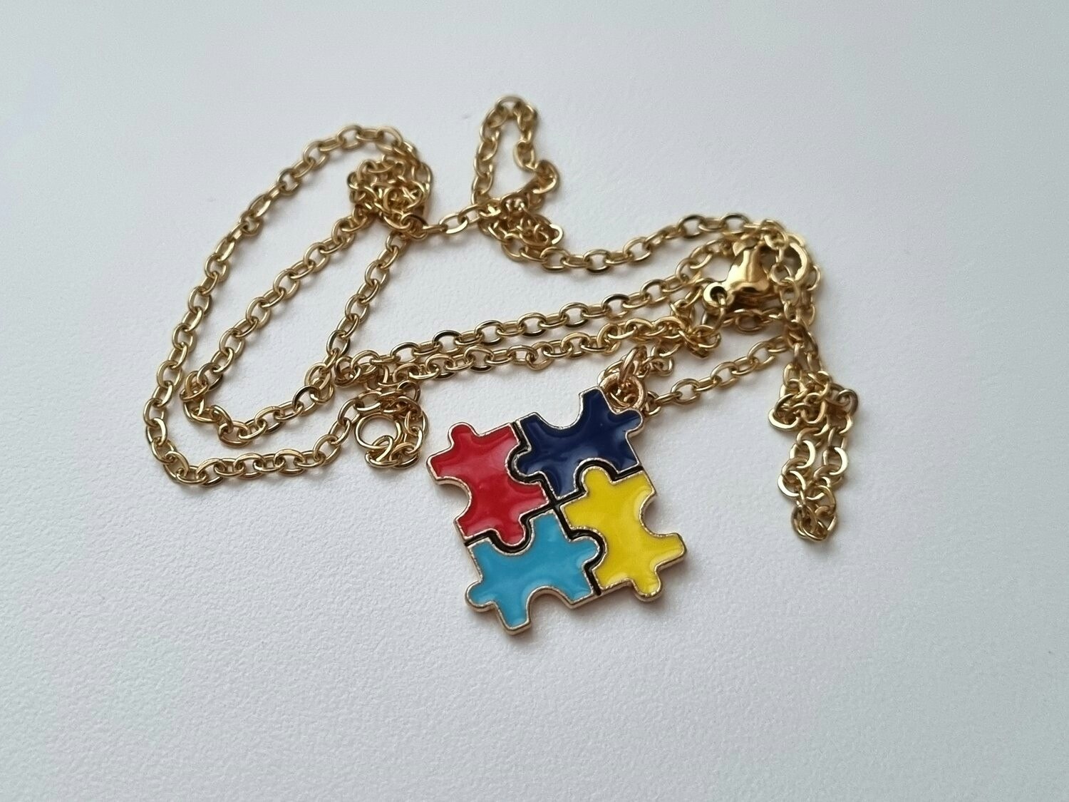 Guldfärgat halsband med en pusselbit / medvetenhet