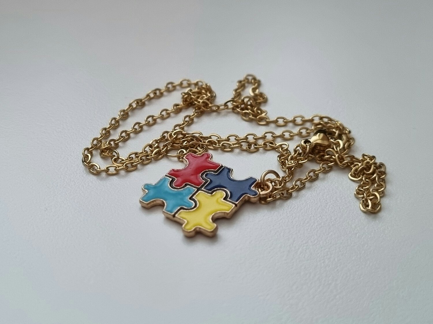 Guldfärgat halsband med en pusselbit / medvetenhet