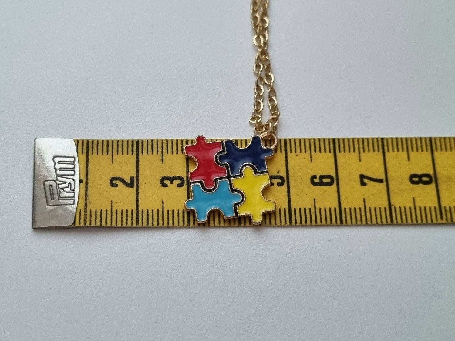 Guldfärgat halsband med en pusselbit / medvetenhet