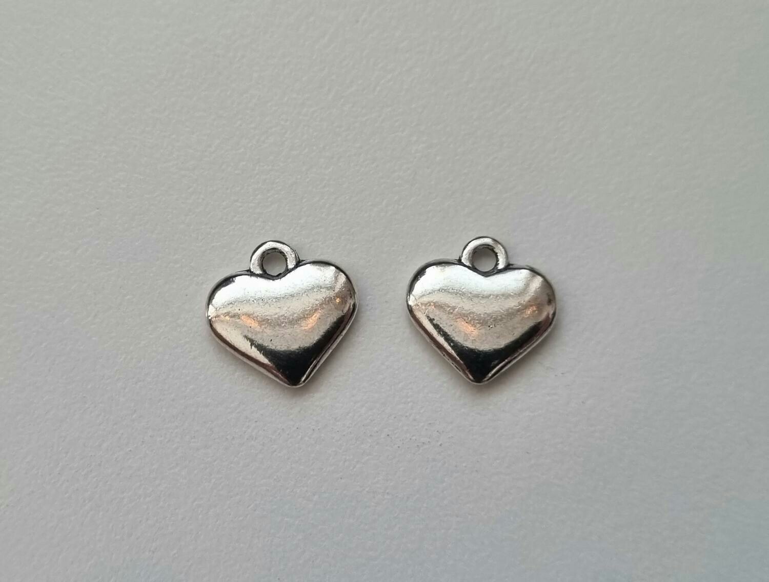 2 st silverfärgade hjärtan. Berlocker / hänge / charm