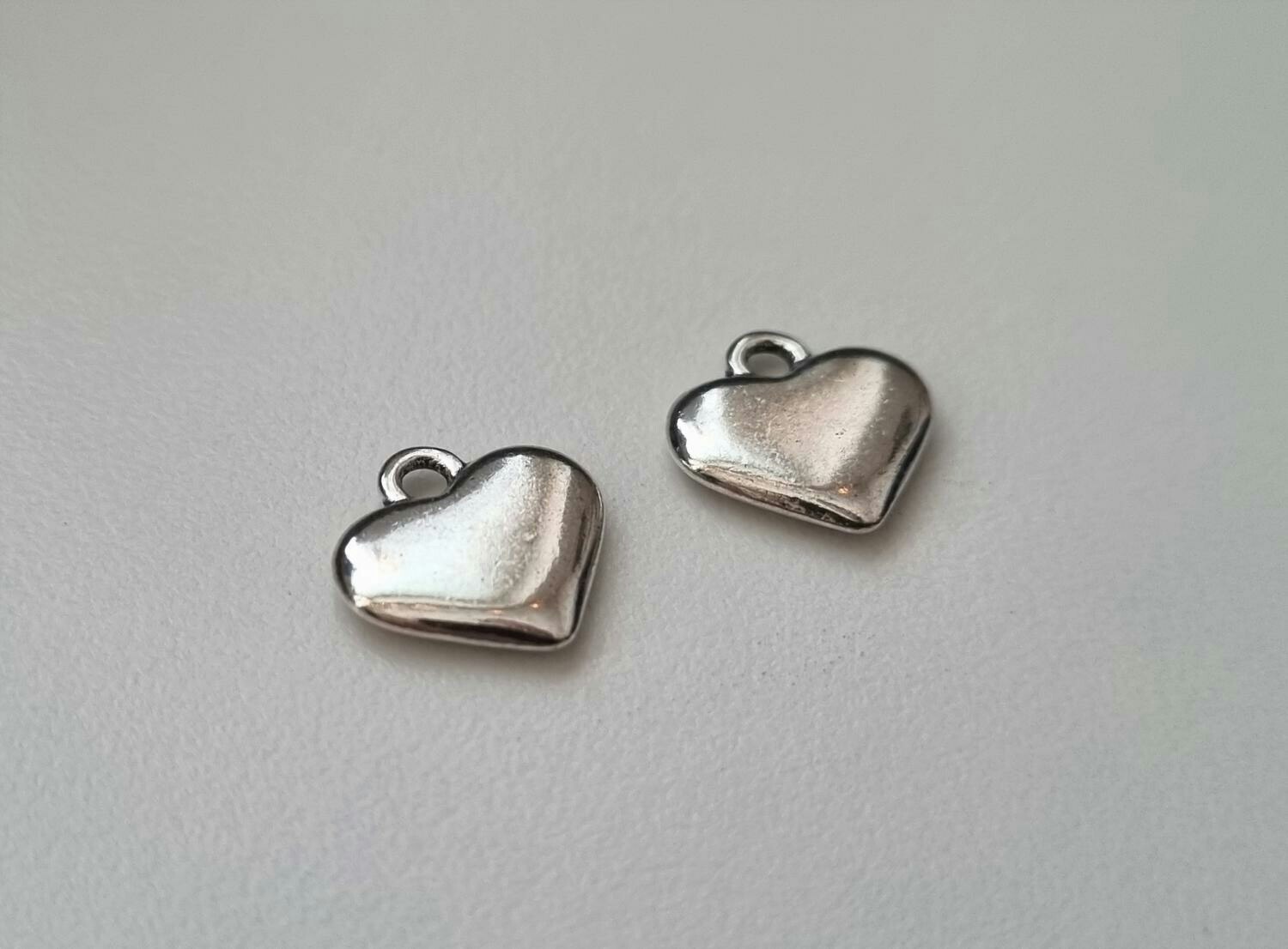 2 st silverfärgade hjärtan. Berlocker / hänge / charm
