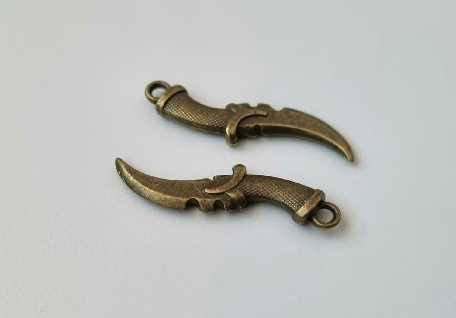 2 st bronsfärgade dolkar. Berlocker / hänge / miniatyrer