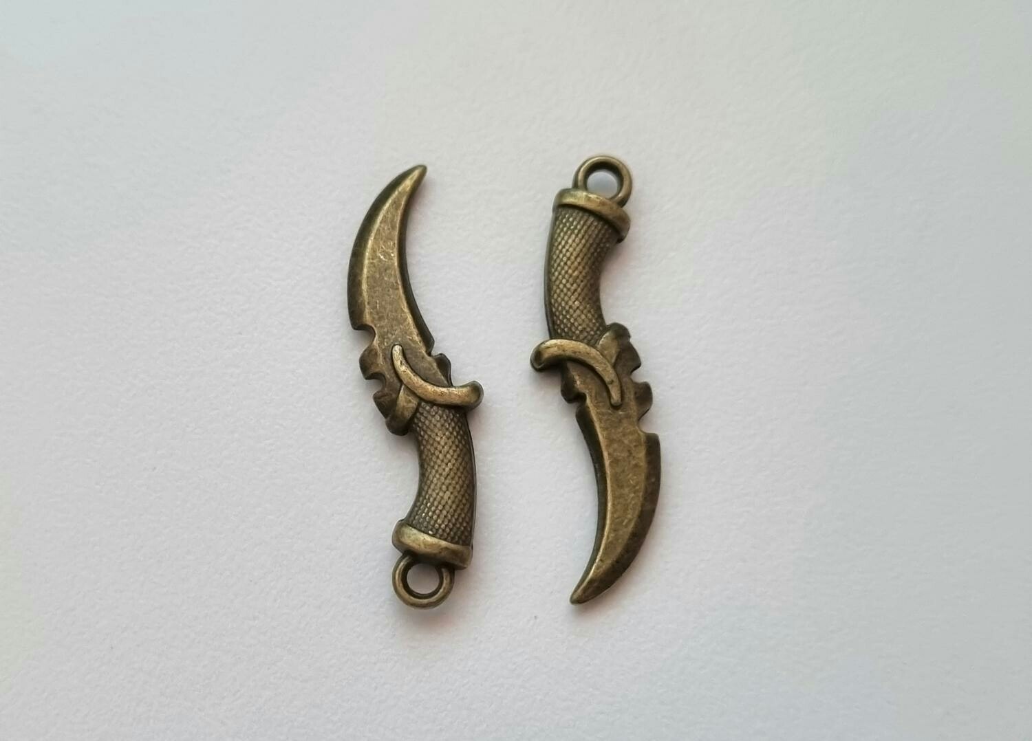 2 st bronsfärgade dolkar. Berlocker / hänge / miniatyrer